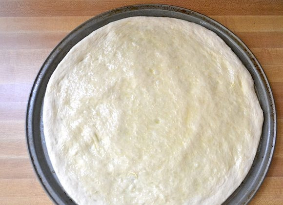 1. Этап. Пицца со шпинатом, луком и сыром: 5. Сформируйте основу под пиццу по форме для запекания. Смажьте тесто оливковым маслом.