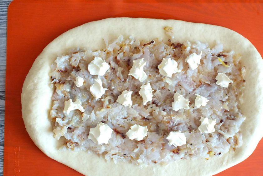 1. Этап. Пирог с пикшей: По истечении времени сформуйте пирог. Тесто раскатайте в пласт, но по краям оставьте небольшие утолщения. Выложите начинку, сверху разложите кусочки сливочного масла.