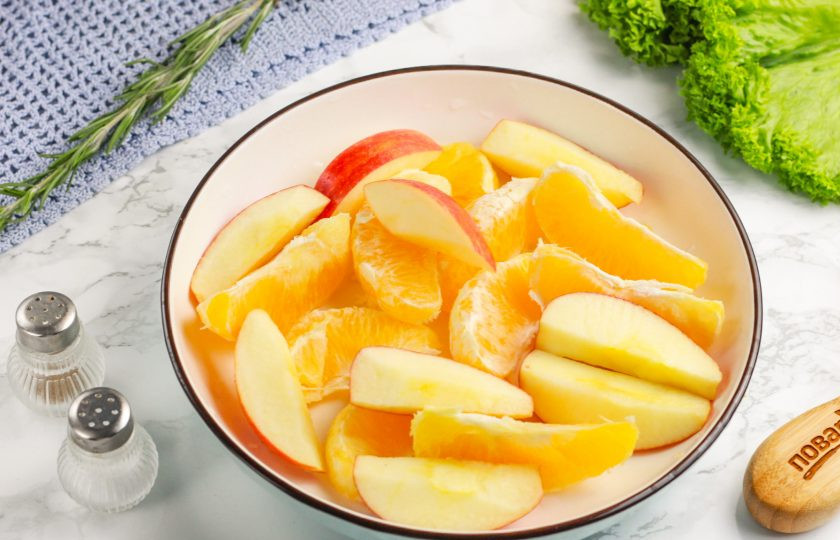 1. Этап. Утка по-французски: Очистите апельсин от оставшейся кожуры, разделите его на дольки. Яблоко разрежьте на части и вырежьте семенные блоки. Нарежьте мякоть крупными ломтиками. Если утка крупная, то используйте 2-3 яблока.