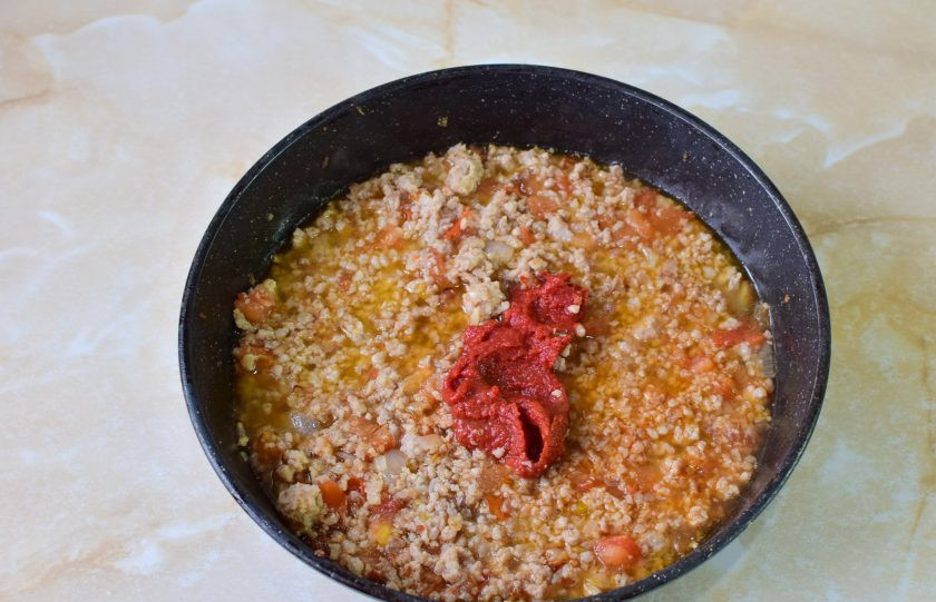 1. Этап. Спагетти по-болонски: Затем добавьте томатную пасту и горячую воду. По вкусу подсыпьте соль и специи. Все перемешайте и накройте крышкой. Тушите на небольшом огне 4-5 минут.