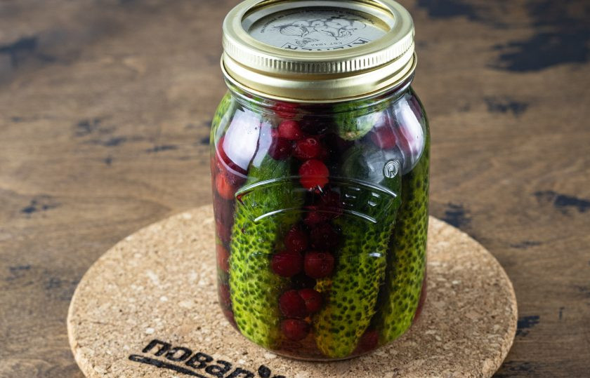 1. Этап. Огурцы с медом и клюквой: Влейте горячую воду и прикройте банку, оставьте на 10 минут.