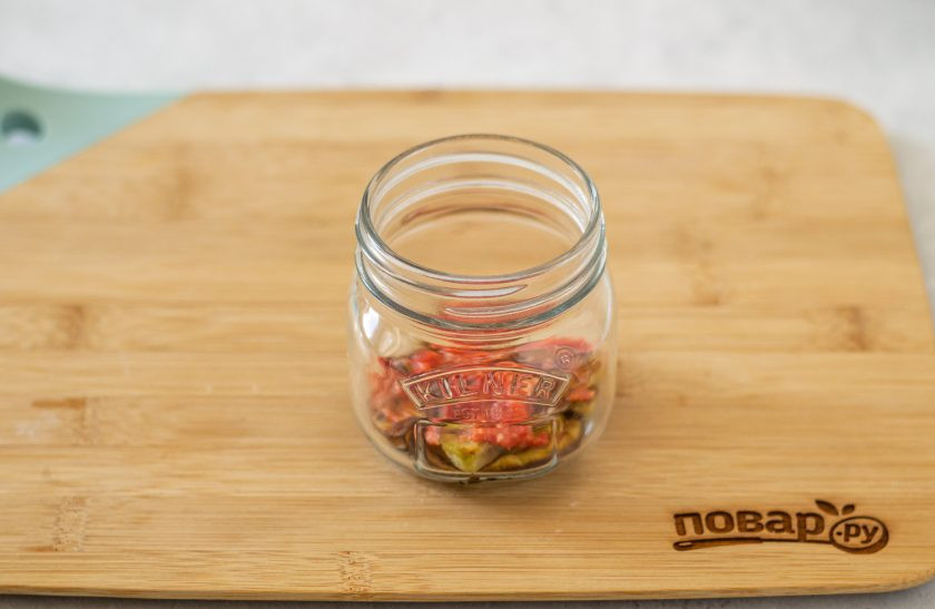 1. Этап. Баклажаны с острым перцем и чесноком: Подготовьте чистую стерилизованную банку. Выложите кружочки баклажанов на дно, чередуя их смесью из чеснока и острого перца. Складывать нужно плотно.