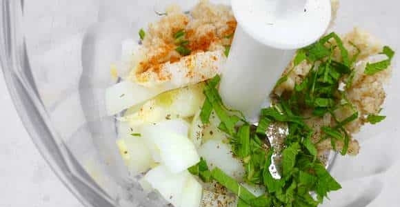 1. Этап. Тефтели в соусе Кефтедес: 1. В чашу блендера отправьте половину очищенного лука и чеснока, замоченный на пару минут и отжатый хлеб, зелень. Добавьте соль, перец, корицу.