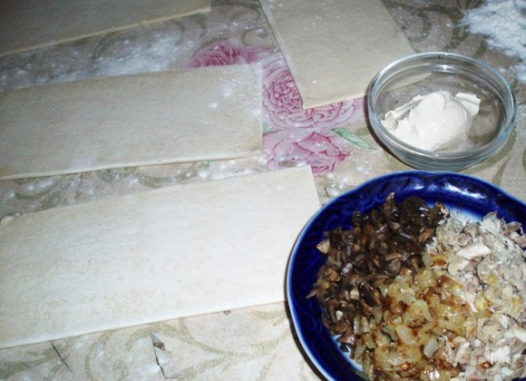 1. Этап. Жюльен в слоеном тесте: Подготовьте все ингредиенты. Отварите куриное филе до готовности. Шампиньоны обжарьте с репчатым луком. В чашке смешайте обжаренные шампиньоны с луком с куриным филе. Посолите, поперчите по вкусу. Нарежьте тесто прямоугольниками.