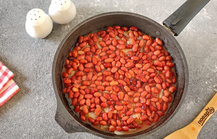 1. Этап. Минтай с фасолью в томатном соусе: Сверху равномерно распределите консервированную фасоль вместе с томатным соусом. Накройте сковороду крышкой и тушите на небольшом огне 10 минут.