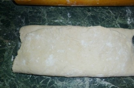 1. Этап. Пирожки из бездрожжевого теста: Сверните нижнюю часть.
