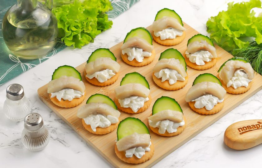 1. Этап. Крекеры закусочные: Нарежьте половину огурца кружочками и разрежьте каждый из них пополам.