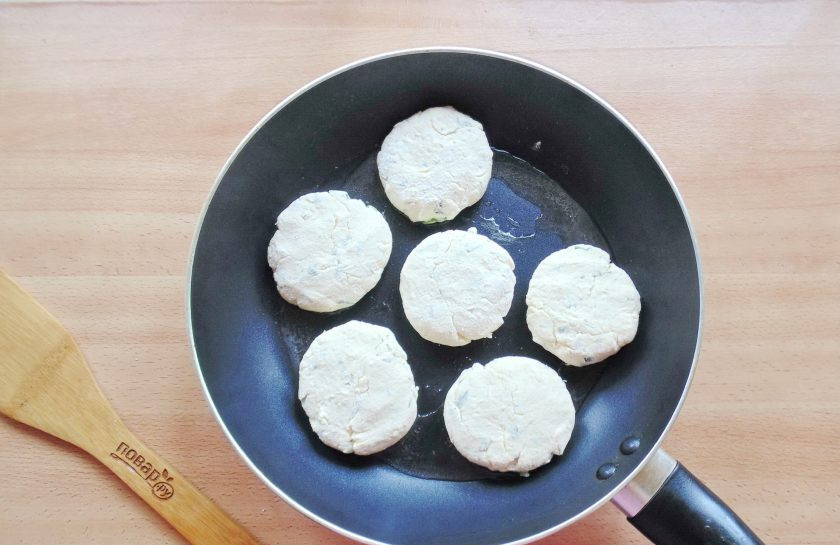1. Этап. Сырники с луком: Из теста сформируйте небольшие лепешки, обваляйте их в муке и выложите на горячую сковороду с подсолнечным маслом.