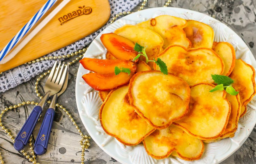 1. Этап. Оладьи на кефире с персиками: Выложите золотистые оладьи на тарелку и подайте к столу теплыми, созвав родных на чаепитие с выпечкой.