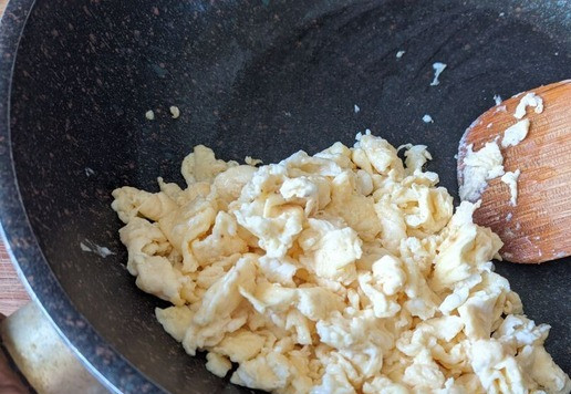 1. Этап. Корейский сэндвич с яичницей-болтуньей: Выливаем яичную массу на разогретую сковороду. Когда яйца немного “схватятся”, начинаем их перемешивать деревянной лопаткой. Жарим яичницу на среднем огне, постоянно перемешивая лопаткой, до тех пор, пока яичница не приобретёт желаемую консистенцию. В конце солим.