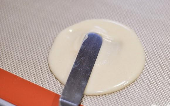 1. Этап. Тюиль с ягодами и взбитыми сливками: 3. Выложить 1 столовую ложку теста на подготовленный противень и, используя маленький шпатель, аккуратно разровнять его. Оно должно быть около 10 см в диаметре. Добавить еще 3-4 столовые ложки теста на противень, оставляя расстояние между каждым печеньем около 7 см.