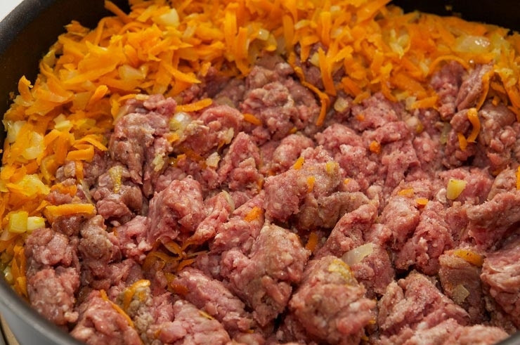 1. Этап. Лазанья с фаршем и овощами: 2. Добавьте измельченный чеснок и натертую на терке морковь. Следом выложите фарш. Это может быть как говяжий или свиной, так и куриный, например.
