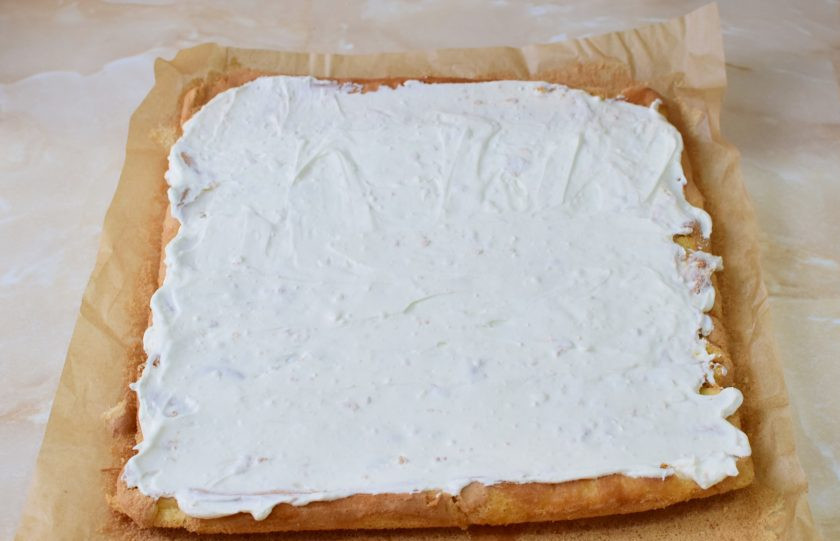 1. Этап. Бисквитный рулет с кремом из сливок: Остывший рулет разверните. Пропитайте его любым сиром или водой. Затем смажьте кремом из сливок.