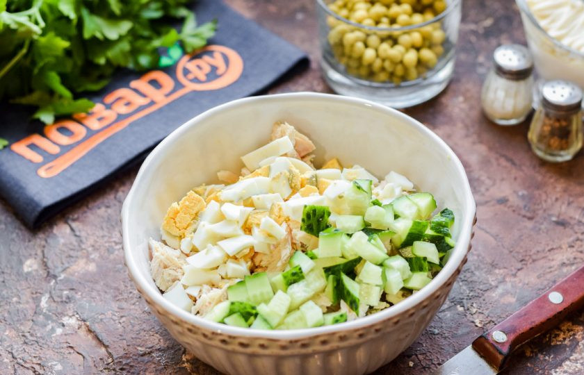 1. Этап. Оливье с курицей и авокадо: Нарежьте кубиками вареные яйца и свежий огурец, добавьте к остальным ингредиентам.