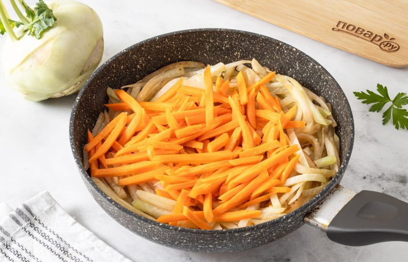 1. Этап. Тушеная капуста кольраби: Влейте в сковороду небольшое (около 50-70 мл.) количество воды. Добавьте морковь, перемешайте и тушите под крышкой 3-4 минуты.