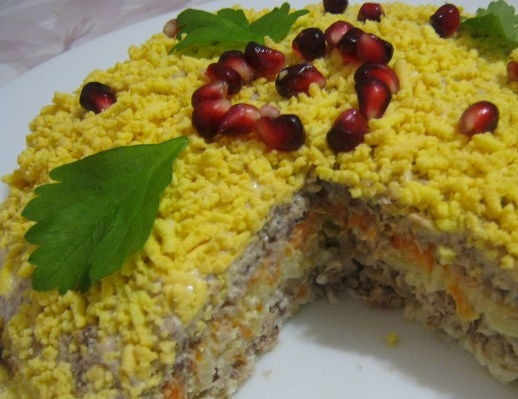 1. Этап. Салат Мимоза с консервой и сыром: 6. На блюдо выкладывайте салат послойно. Каждый слой смазывайте сеткой из майонеза. Смочите водичкой дно блюда и положите первый слой – тертый белок. На него уложите одну часть консервы. Затем выложите слой лука. Следующий слой – тертый картофель. Сверху картофеля – натертая морковка. На нее оставшуюся часть консервы. Засыпьте все желтком. Сверху присыпьте небольшим количеством тертого сыра. Теперь, когда вы знаете, как приготовить салат мимоза с консервой и сыром, украсьте его веточками зелени и зернышками граната. Поставьте на пару часов в холодильник. Все готово, можно пробовать. Приятного аппетита.