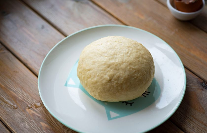 1. Этап. Вареники на кефире и дрожжах: Замесите мягкое, не прилипающее к рукам тесто, округлите его в миске, накройте кухонным полотенцем и оставьте в условиях теплой кухни на полчаса. Возможно для достижения правильной структуры теста вам потребуется чуть больше муки — корректируйте это количество самостоятельно.