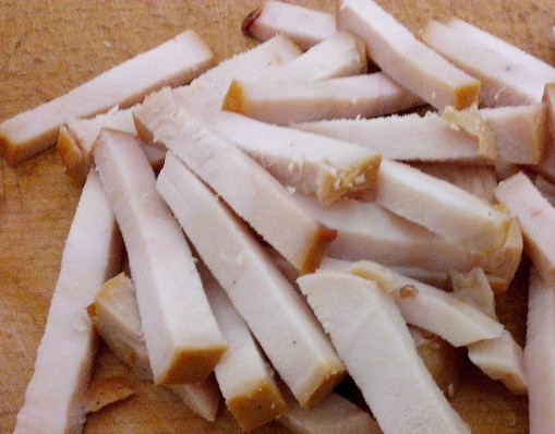 1. Этап. Салат с копченой курицей и кукурузой: Достаем копченую курицу, либо ее часть. Это могут быть окорочка или чистое филе. Отделяем мясо от кости и нарезаем полосочками. Кстати, курицу можно вполне заменить индейкой.