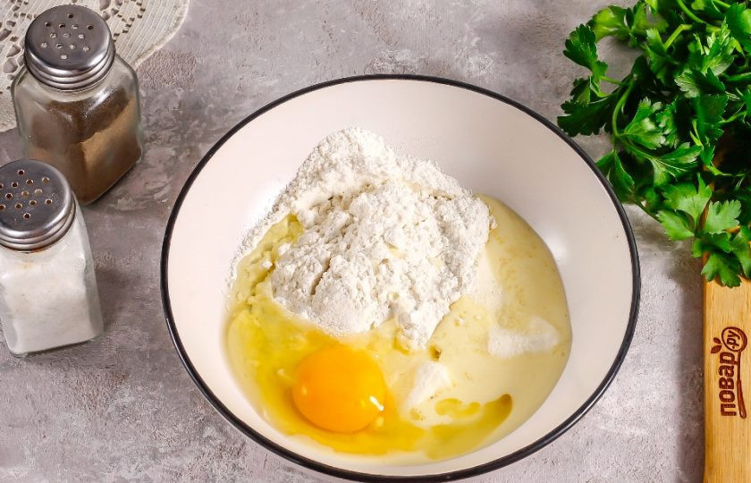 1. Этап. Сырный пирог: Прогрейте сливочное масло в глубокой емкости в микроволновке или на водяной бане, но не до кипения. Вбейте в емкость куриное яйцо и всыпьте соль, пшеничную муку. Быстро замесите песочное тесто и оставьте его на 15 минут в покое, накрыв пищевой пленкой. Муки может потребоваться чуть больше, исходя из размеров яйца.