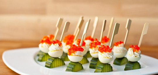 1. Этап. Канапе на свадьбу: 4. На праздничном столе всегда потрясающе смотрится красная икра. Однако подать ее можно не только на традиционных бутербродах, но и в виде изысканных канапе. Половинку перепелиного яйца необходимо наполнить сливочным маслом (лучше всего для этого использовать кондитерский шприц) и сверху выложить икру. Подавать такую закуску можно на кусочке свежего огурца, который отлично дополняет вкус икры. Такие канапе на свадьбу в домашних условиях можно подавать и в куриных яйцах.