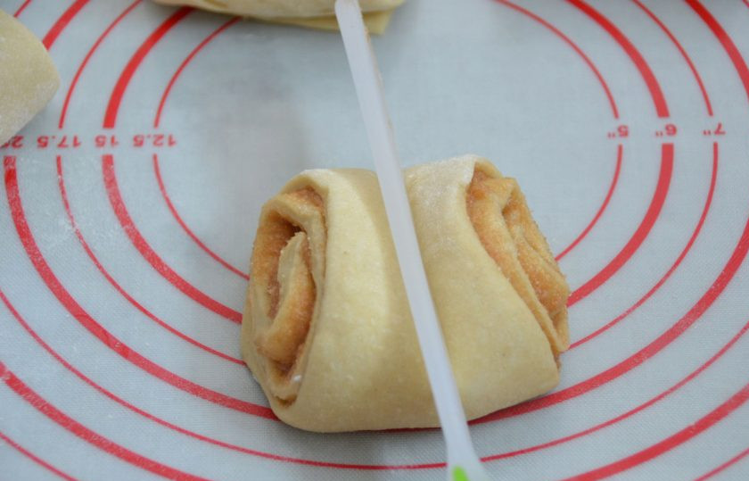 1. Этап. Финские булочки с корицей и кардамоном: Поставьте булочку на основание, на широкую сторону, приплюсните сверху с узкой стороны с помощью подходящего предмета.