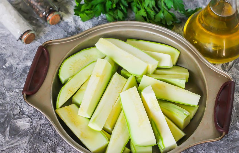 1. Этап. Диетические кабачки в духовке: Кабачки промойте в воде, срежьте хвостики с обеих сторон овощей и нарежьте их крупными брусочками. Смажьте форму для запекания растительным маслом, лучше всего - оливковым холодного отжима. Выложите в форму кабачковую нарезку.