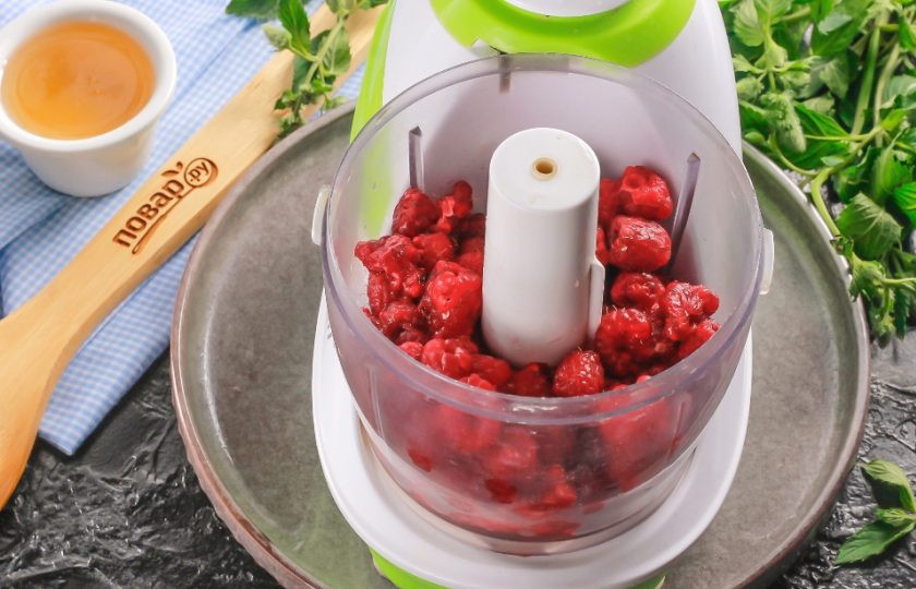 1. Этап. Малина с медом на зиму без варки: Ягоды выложите на бумажную салфетку и промокните другой салфеткой, удаляя лишнюю влагу. Затем переместите в чашу измельчителя или кухонного комбайна, блендера.