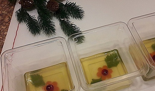 1. Этап. Рождественский холодец из шеек индейки: Для тех кто любит желатиновый бульон: на дно формы положить предметы для украшения холодца (у меня - колечки моркови, ягодки клюквы, листики петрушки). Слегка залить желатиновым бульоном, поставить в холод на несколько минут, чтобы украшения прихватились.