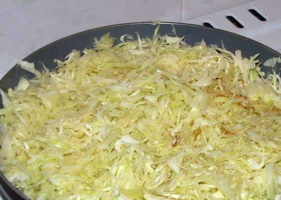 1. Этап. Капустная запеканка с мясом: Нашинкуйте капусту и обжарьте в течение 5 минут на сковороде. Затем добавьте 0,5 стакана воды и тушите еще 7-8 минут до готовности.