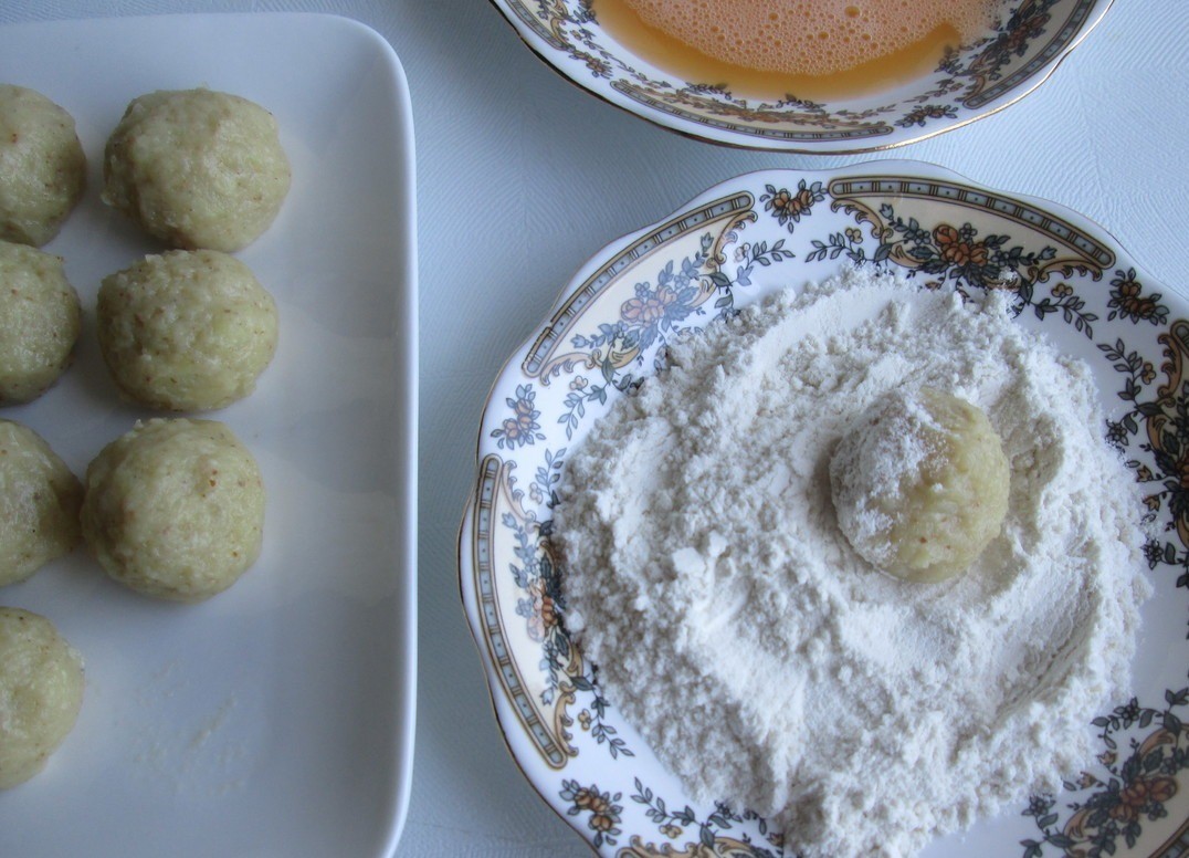 1. Stage. Potato balls salad: Roll the potato mass into balls. We got 16 pieces. Put two saucers: in one - half of the beaten egg, in the second - flour (3-4 tbsp.). Roll each ball first in flour, then in egg, and again in flour.