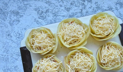 1. Этап. Картофельные розочки с тунцом: Сыр натираю на мелкой терке и укладываю поверх начинки. Форму накрываю фольгой, чтобы картофельные лепестки не начали подгорать и ставлю запекаться в духвку. разогретую до 190 градусов на 30 минут. Когда картофель полностью приготовится. Снимаю фольгу. С помощью силиконовой кисточки, смазываю картофельные лепесточки растительным маслом, смешанным с паприкой и запекаю под грилем еще 5 минут.