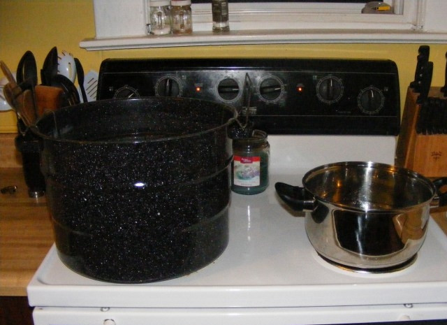 1. Этап. Салат из свежих огурцов на зиму: 2. В сотейник вливаю воду, добавляю уксус и сахар, довожу смесь до кипения и размешиваю крупинки, после этого убираю с огня. Большую кастрюлю заполняю немного водой, нагреваю в ней воду.