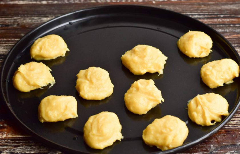 1. Этап. Профитроли с банановым кремом: Выложите тесто на противень ложкой. Отправьте в разогретую до 190 градусов духовку на 30 минут.