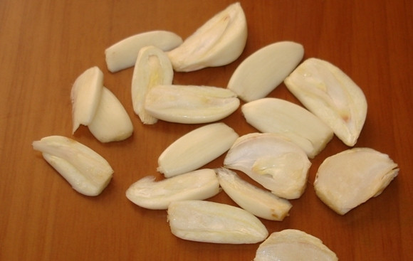 1. Этап. Свинина с чесноком в духовке: 1. Рецепт приготовления свинины с чесноком в духовке начинается за 10-12 часов до запекания мяса. Чеснок необходимо очистить и порезать небольшими дольками.