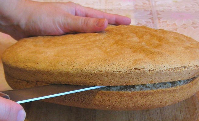 1. Этап. Самый быстрый бисквитный торт: Готовый бисквит слегка остудите, затем разрежьте ножом пополам.