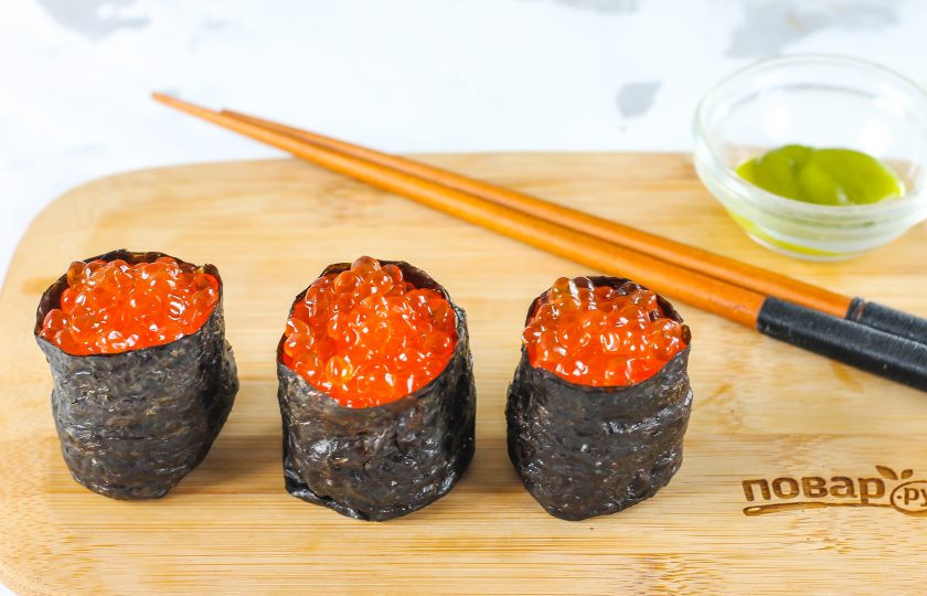 1. Этап. Гунканы: В лодочку выложите плавленый сыр, ломтик авокадо и заполните ее красной икрой до верха. По желанию можно сделать гунканы с разными начинками: нарезкой слабосоленой красной или другой рыбы, овощной нарезкой и т.д.