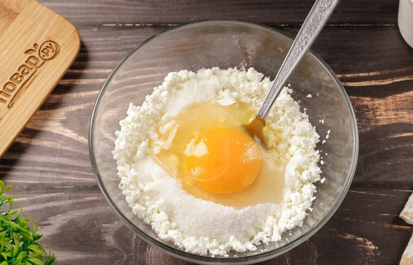 1. Этап. Заливной пирог на кефире с творогом: В глубокой миске творог разотрите вилкой. Затем добавьте одно яйцо, 2 ст.л. сахара и ванильный сахар или ванилин.