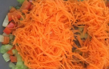 1. Этап. Слоеные пирожки с фаршем и овощами: Морковку трем на мелкой терке и добавляем на сковороду к остальным овощам.