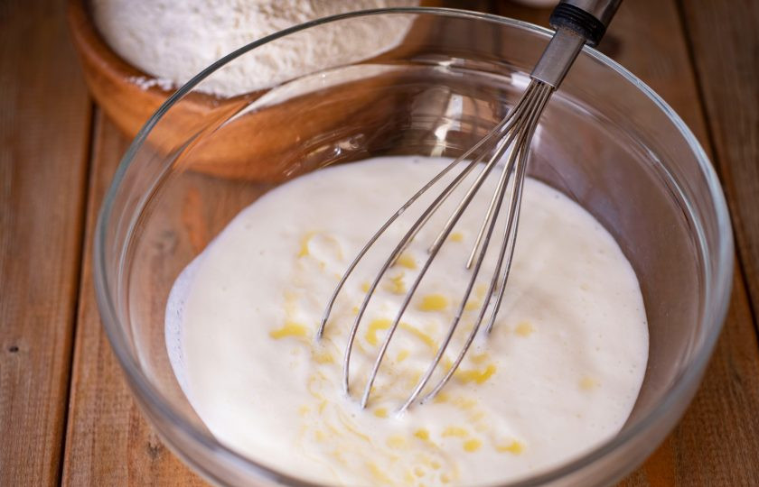 1. Этап. Хачапури по-аджарски на кефире: Залейте сливочное масло, растопленное в сотейнике на маленьком огне. Перемешайте венчиком.