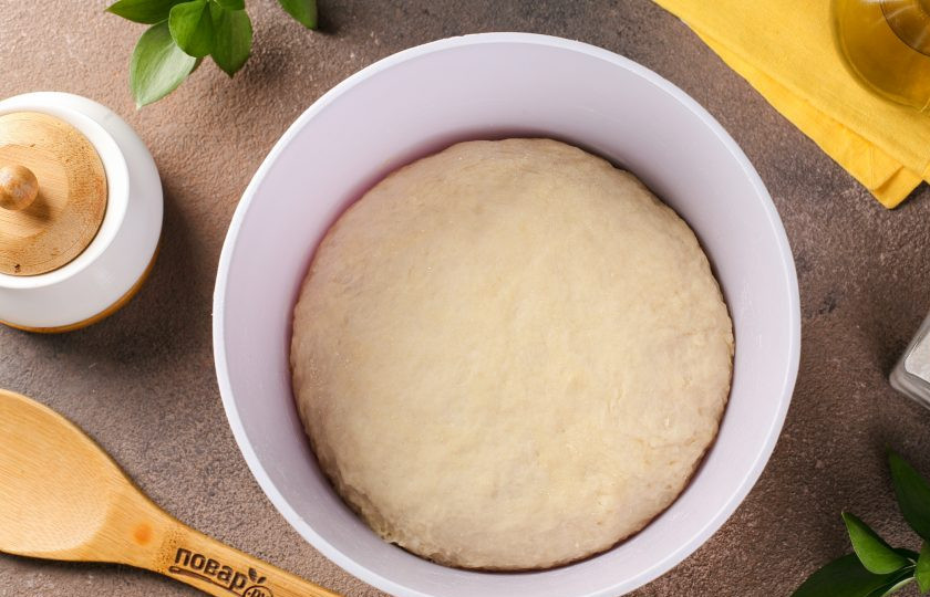 1. Этап. Пышные жареные пирожки на кефире с дрожжами: Затем переложите тесто на посыпанную мукой рабочую поверхность и продолжите замес руками. Дрожжевое тесто любит руки, поэтому месить его лучше не менее 15 минут. Соберите тесто в шар, переложите обратно в миску, накройте полотенцем и оставьте в тёплом месте на 2 часа.