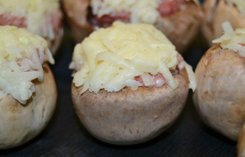 1. Этап. Фаршированные грибные шляпки: 6. Уложите сырную смесь поверх фарша. Выложите грибочки на противень.