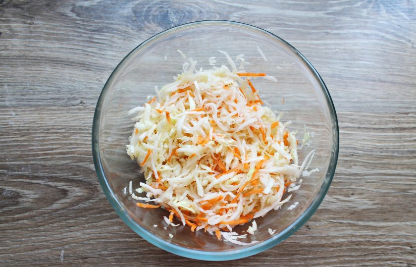 1. Этап. Салат с капустой и дайконом: Овощи посолите, перемешайте и немного помните, чтобы они пустили сок и стали мягче.