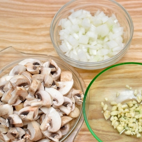 1. Этап. Яичница-болтунья с грибами: Подготовьте ингредиенты. Шампиньоны нарежьте на 4 части каждый, лук и чеснок мелко нашинкуйте.