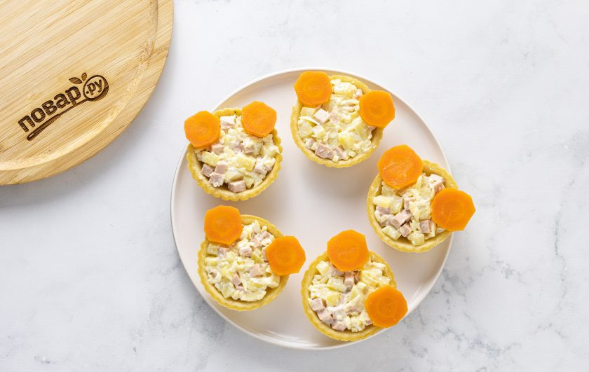 1. Этап. Тарталетки Тигрята: Для украшения нарежьте часть моркови кружочками, выложите ушки будущих тигрят.