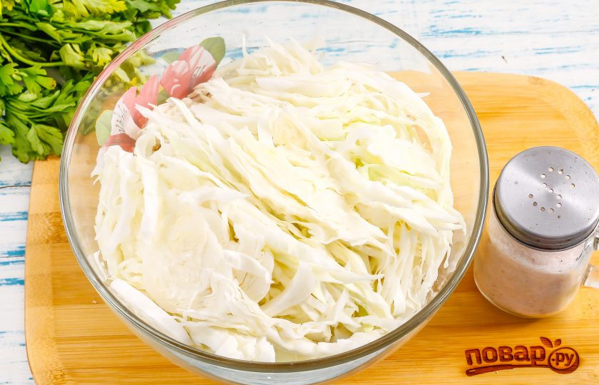 1. Этап. Квашеная капуста как на рынке: Капусту очистите от верхних листьев, разрежьте пополам и нарежьте любым, удобным для вас способом, но не слишком тонко. По желанию можно воспользоваться специальным девайсом. Выложите нарезку в глубокую емкость.