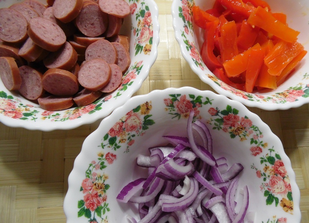 1. Stage. Pizza with meatballs and pickled peppers: Cut hunting sausages in circles, onions - in half rings, peppers - thick julienne.