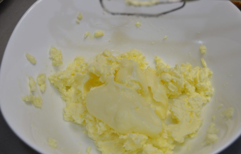 1. Этап. Мандариновый торт на Новый год: Взбейте сливочное масло комнатной температуры, добавляя по одной столовой ложке заварной крем.