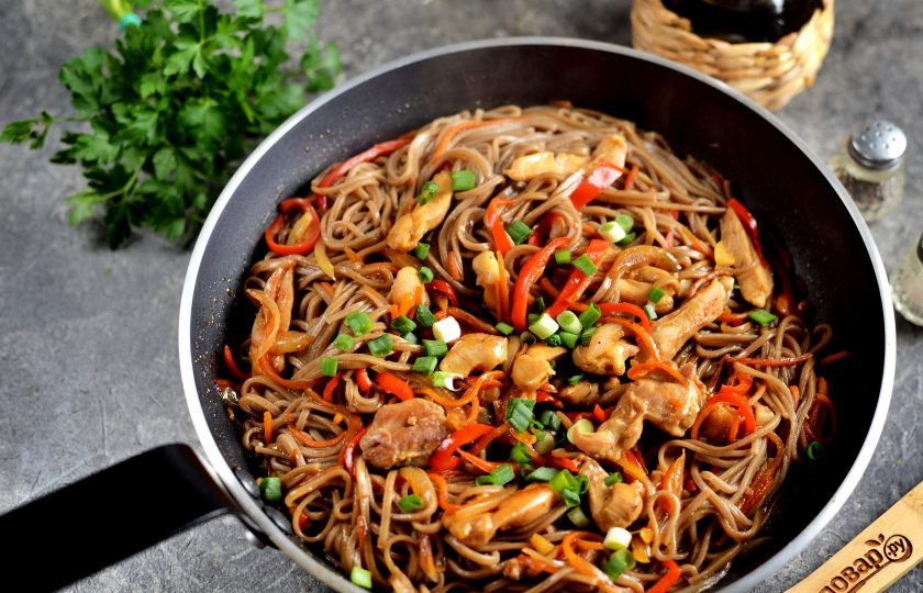 1. Этап. Лапша по-корейски с курицей: Переложите в сковороду лапшу, поперчите все, тщательно перемешайте. Посыпьте готовое блюдо нарубленным зеленым луком.