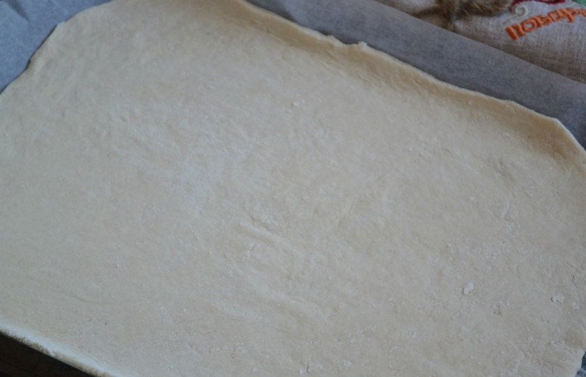 1. Этап. Армянский лаваш: Раскатайте тесто очень тонко, буквально в несколько миллиметров. Выложите его на противень, застеленный пергаментом.