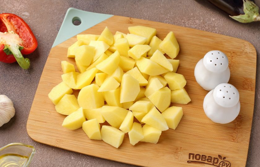 1. Этап. Мясо с баклажанами и картошкой в духовке: Картофель очистите и нарежьте кубиками.